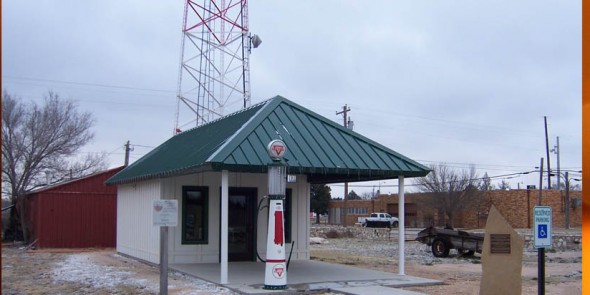 Small security booth with a vintage gas pump outside.