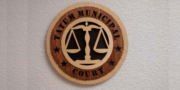 Wooden emblem of Tatum Municipal Court with scales of justice.